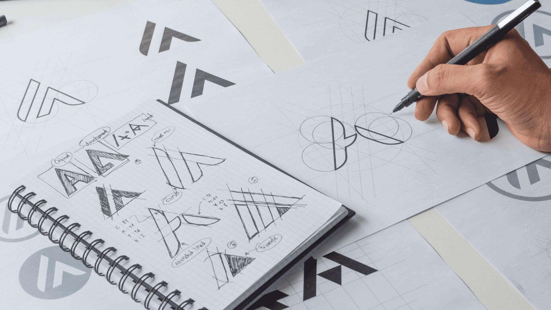 person sketching logos